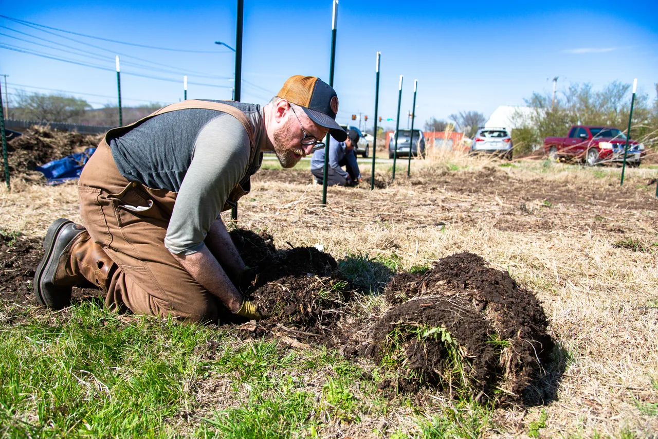 Volunteer digging soil at Flat Rock garden